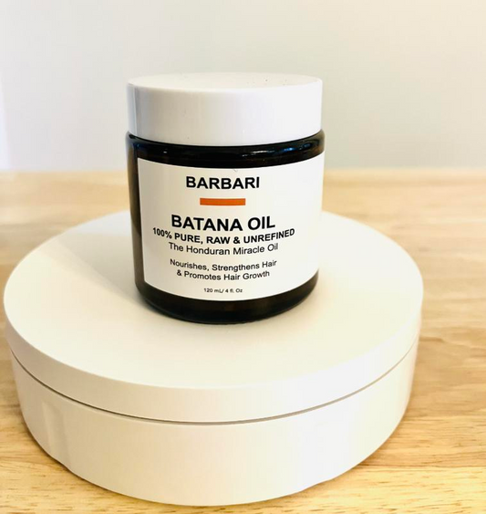 Barbari Batana Oil jar on a wooden surface with a white background