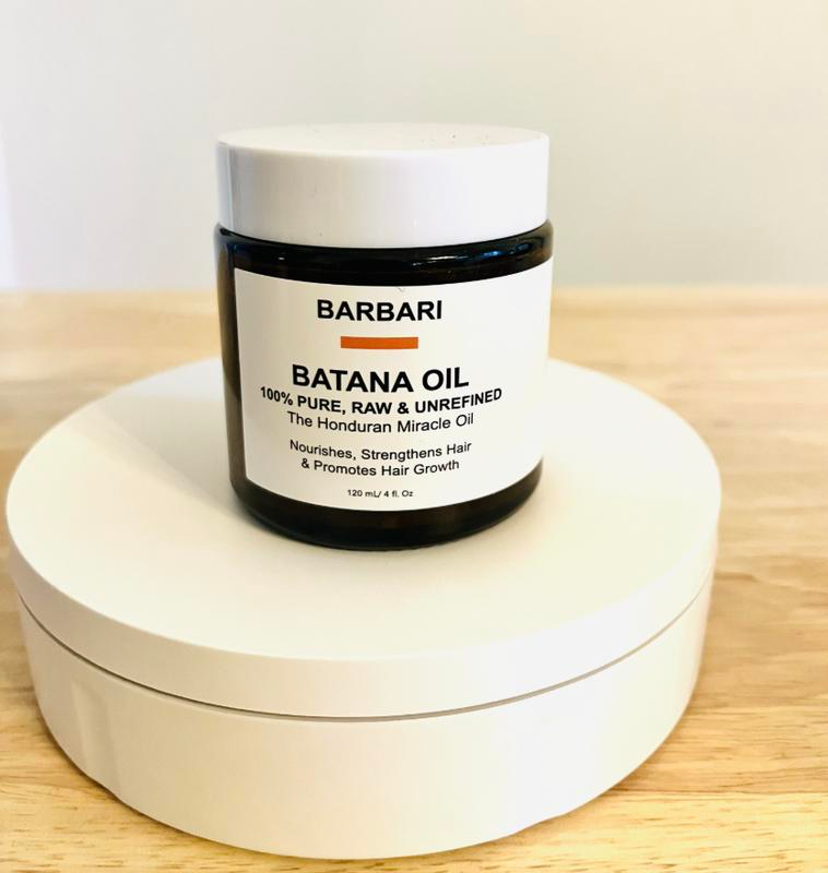 Barbari Batana Oil jar on a wooden surface with a white background